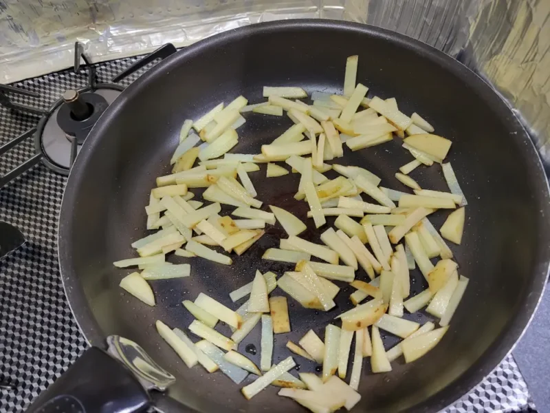 フライパンで細切りの新じゃがを先に炒めている様子