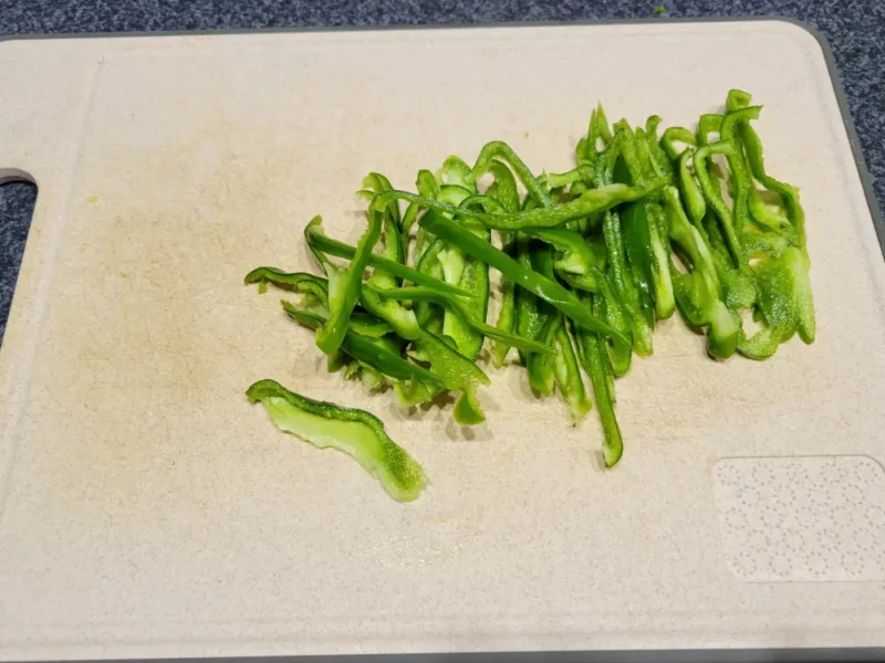 細切りにしたピーマンをまな板の上に並べた様子