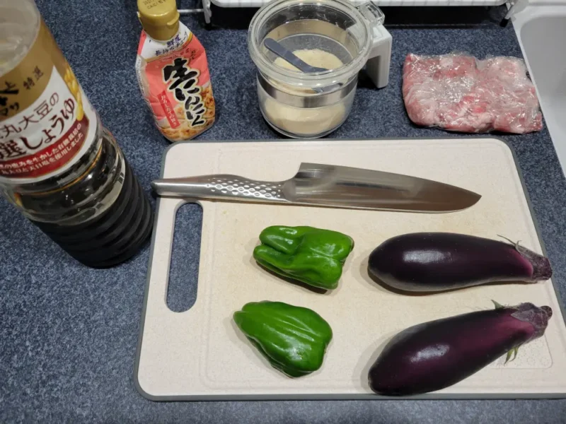 豚切り落とし、なす、ピーマン、調味料を並べた材料写真